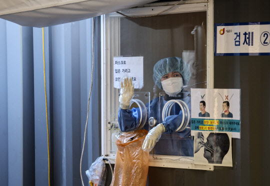 지난 16일 오전 서울역에 설치된 코로나19 임시선별검사소에서 의료진이 업무를 보고 있다. <연합뉴스>